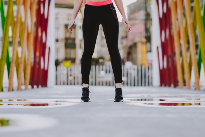 Woman in sportswear standing on street in sunny day