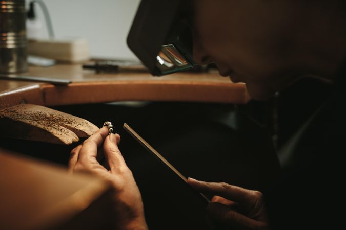 Close up of a female goldsmith working and shaping an unfinished ring