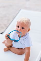 Blond baby playing with sunglasses
