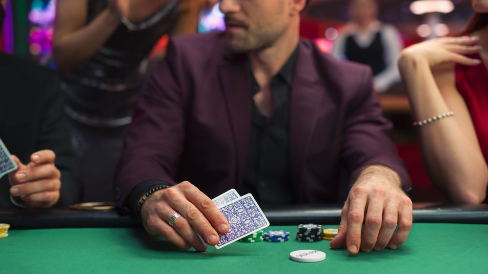 Group of Gorgeous Multiethnic Men and Women Playing in a Game of Poker in Joyful Casino.
