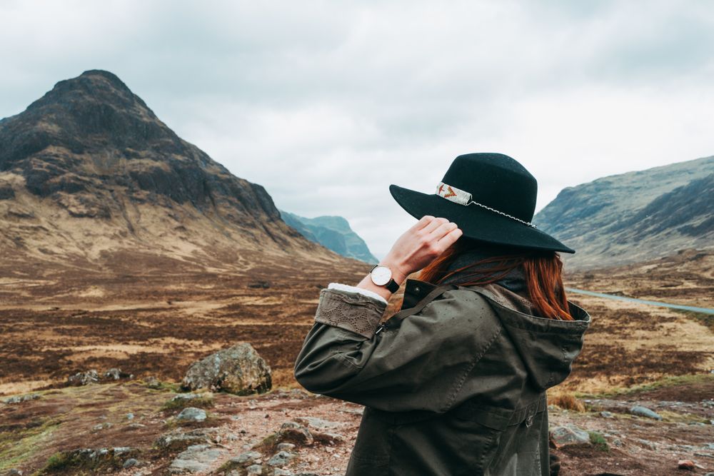 Redhead woman in hat against mountains