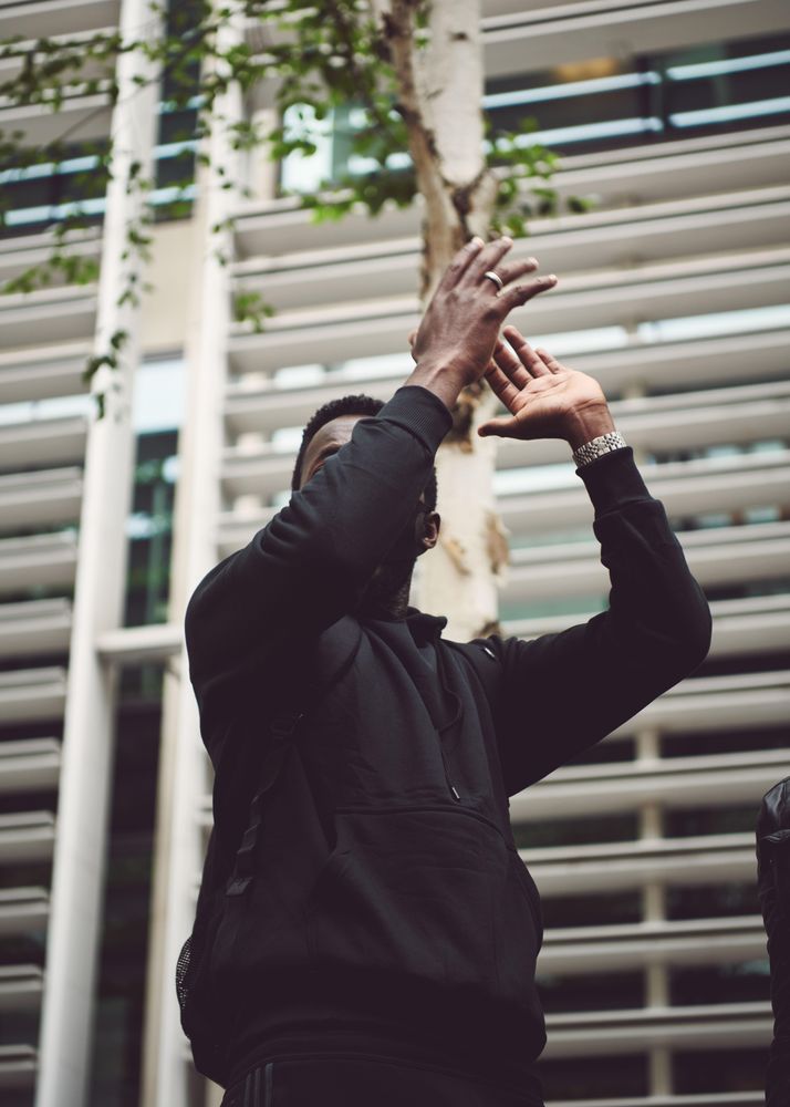 London, England, United Kingdom - June 6th, 2020: Man clapping above his head covering his face