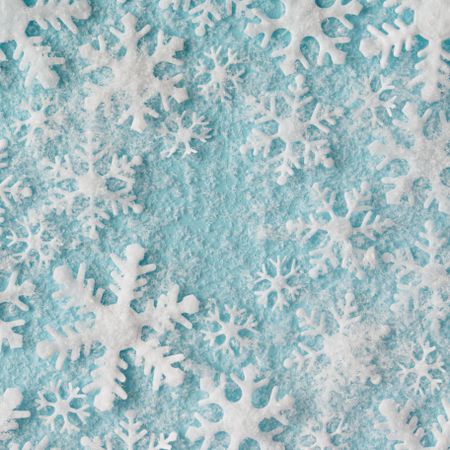 Winter pattern made of different sized snowflakes on blue background