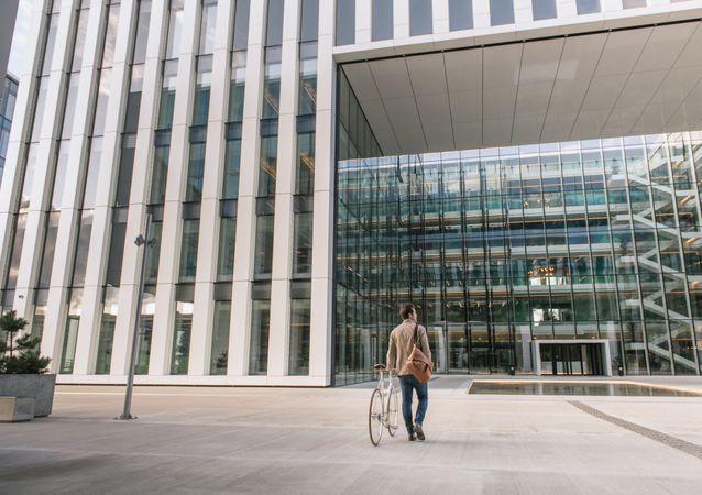 Businessman walking on street with bicycle