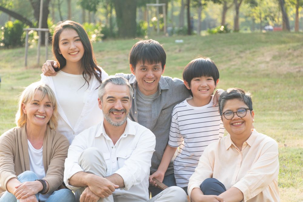 Multi-ethnic friends and family sitting in the park together