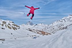Unrecognizable snowboarder jumping on slope