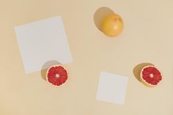 Minimal sunlit fruit composition with sand color background and sharp shadows