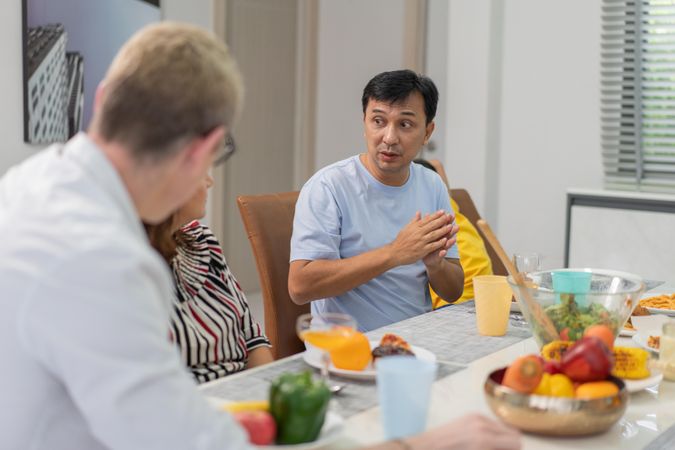 Asian family hosting white couple for dinner