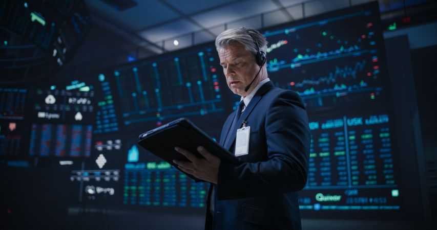 Low Angle Portrait of a Proactive Stock Exchange Manager Working in Modern Office.