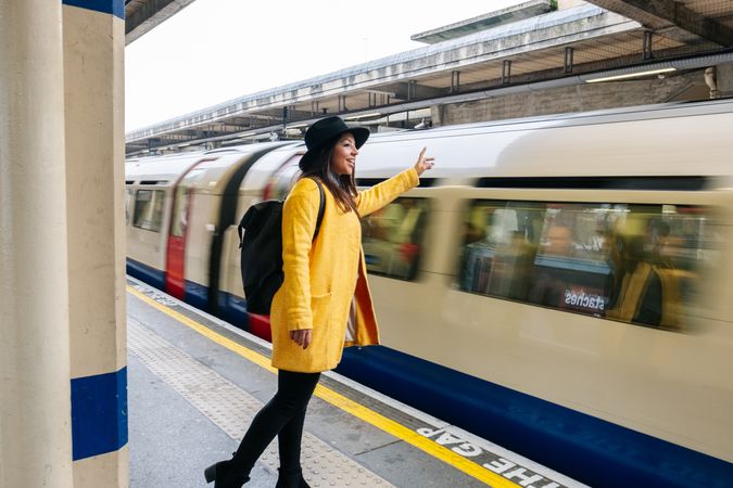 Cheerful woman catching train on station