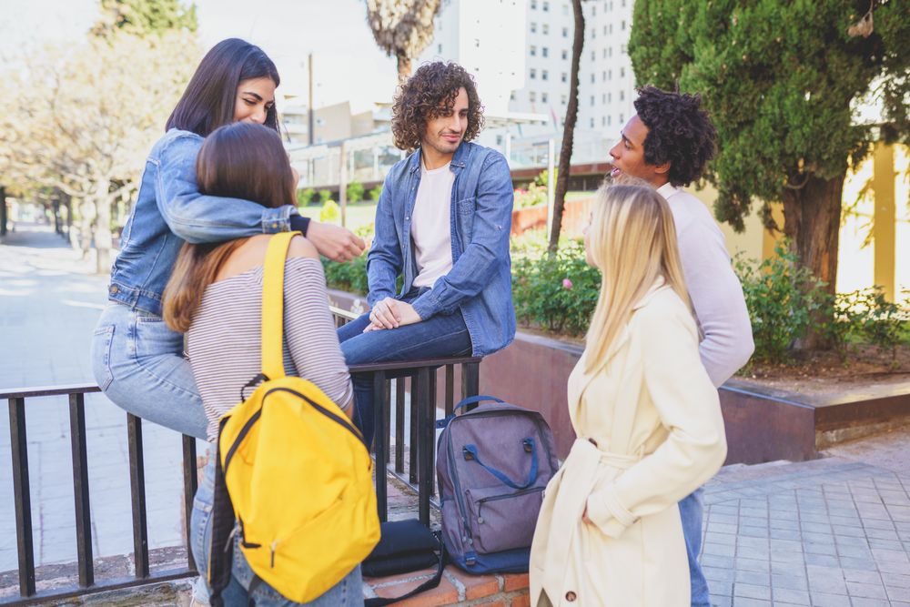 Male and female friends talking outside