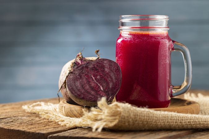 Red beet juice in a glass cup on the wooden table.