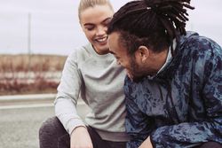 Woman in happy mood as she takes a break from running with her boyfriend