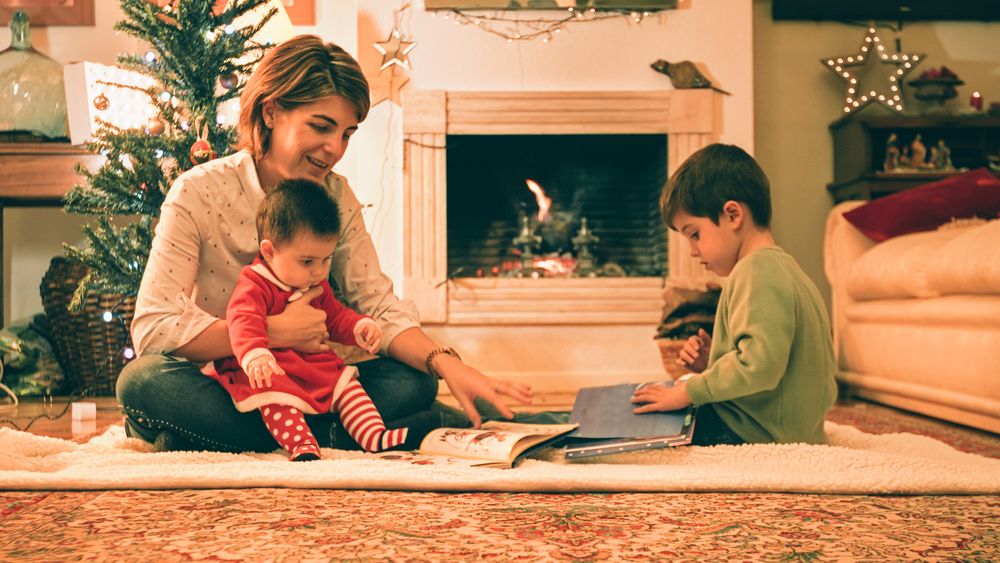 Mother reading book with son on Christmas eve