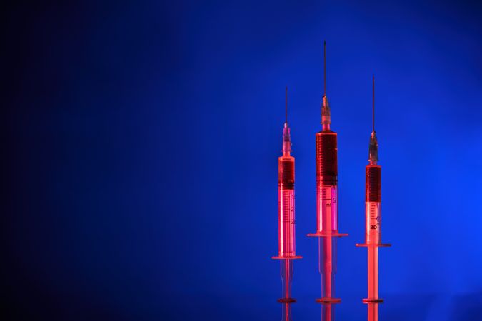 Syringes organized in row on blue background