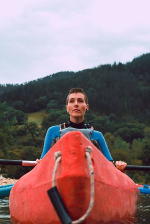 Young female kayaking on nature background