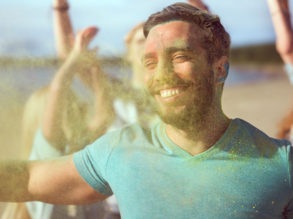 Close-up Portrait of a Muscular Man Dances in Celebration of Holi Festival With His Friends.