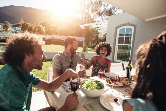 Group of friends hanging out with food and drinks outside home