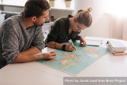 Man and woman studying the world map bGoLlb