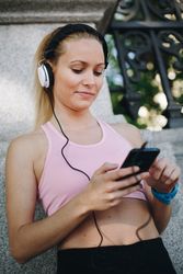 Woman with sportswear listening to music with headphones
