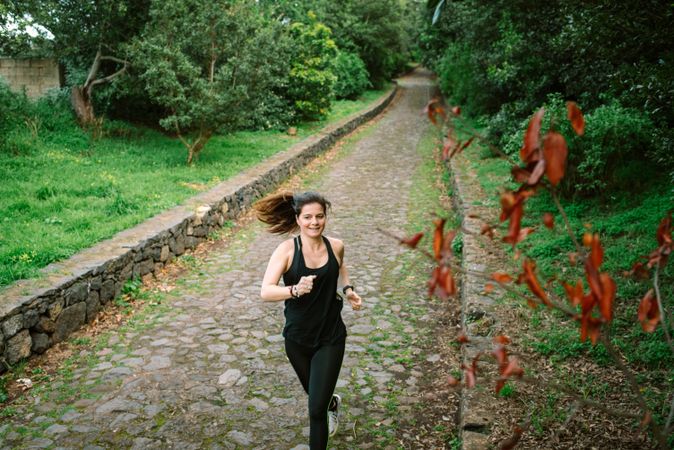 Positive woman running in park