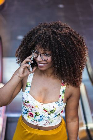 Glad woman speaking on smartphone in park