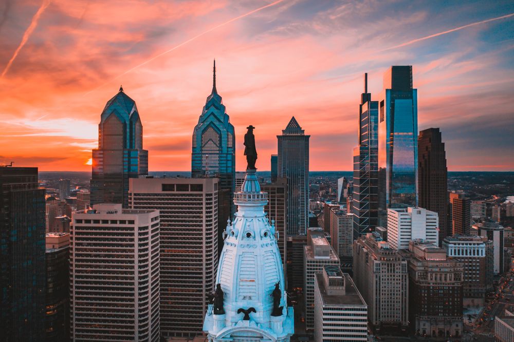 William Penn statue in Pennsylvania city skyline in Philadelphia, US under sunset sky