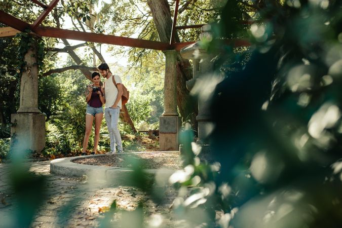 Happy explorer couple taking photographs in a park