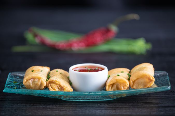 Vietnamese rolls with sweet chili on glass plate