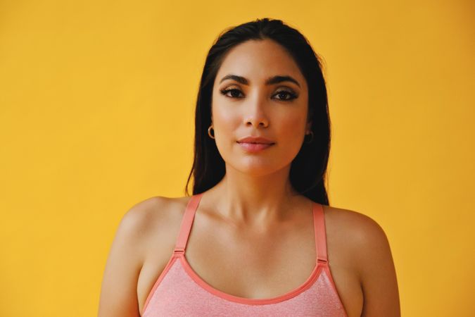 Hispanic woman in yoga clothes looking at camera, close up