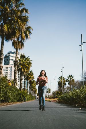 Teen girl walking happily through the streets.