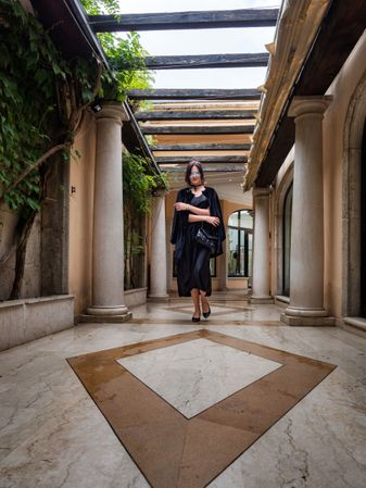 A woman in a dress walks gracefully through the gallery