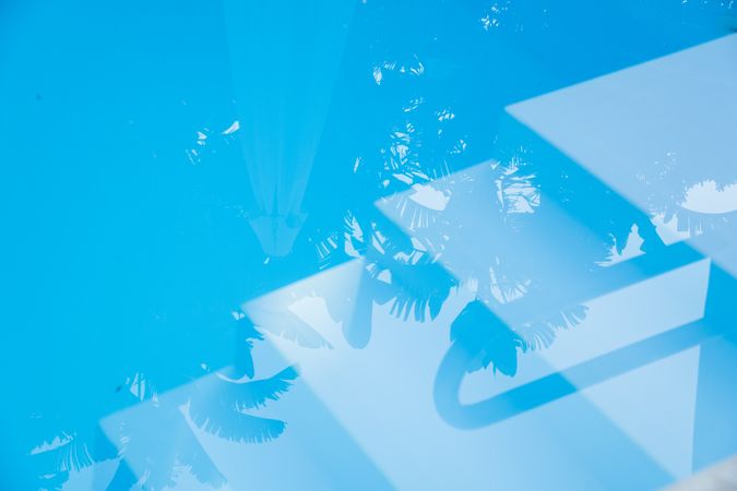 Abstract summer background of a blue swimming pool water texture with light and reflections
