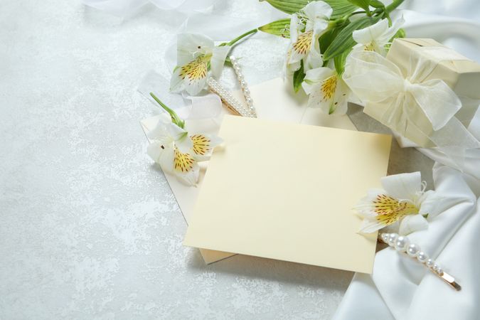 Light yellow paper surrounded with flowers and a gift