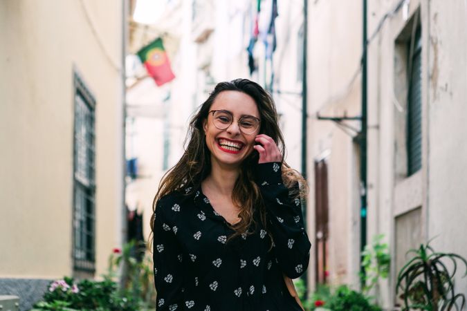 Young casual brunette walking on cobblestone street of old city