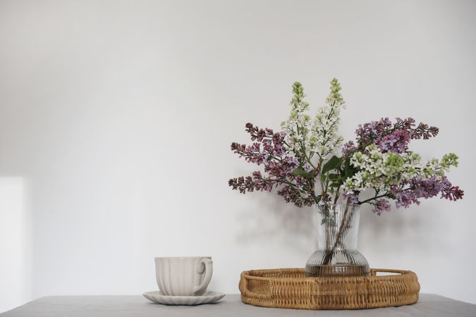 Floral bouquet of blooming purple and lilacs branches in glass vase