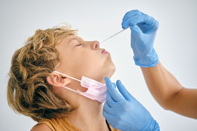 Crop nurse taking COVID test from boy in hospital