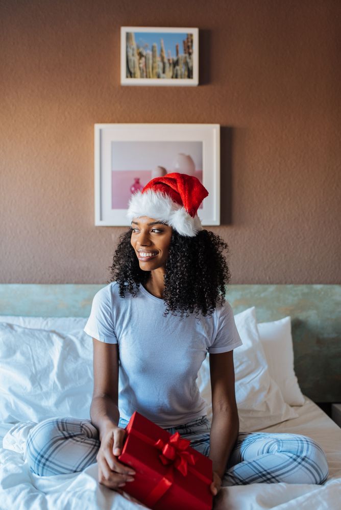 Woman with santa claus hat with a present