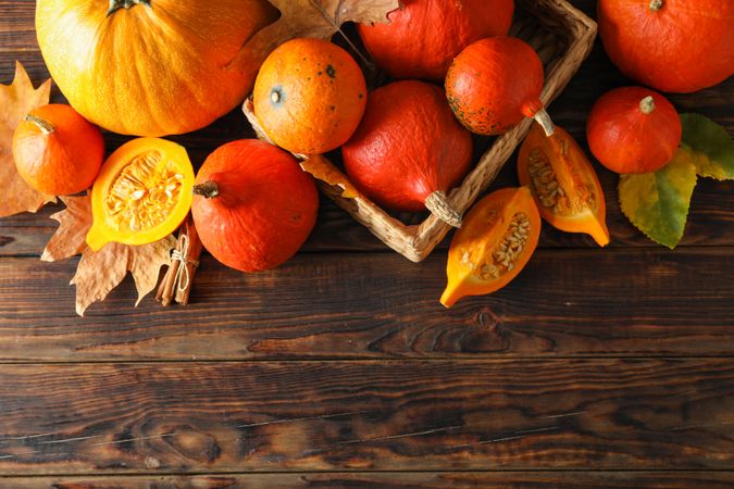 Composition with pumpkins and leaves on wooden background, copy space