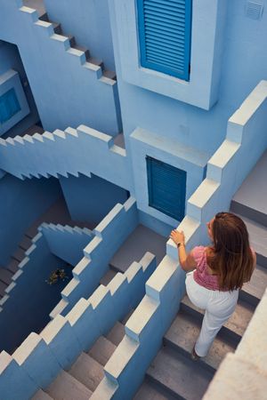Woman walking downstairs on modern blue building