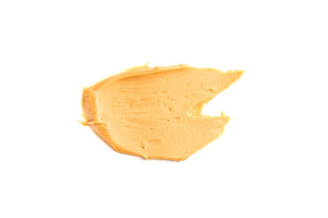 Creamy peanut butter isolated on bright background. A traditional product of American cuisine