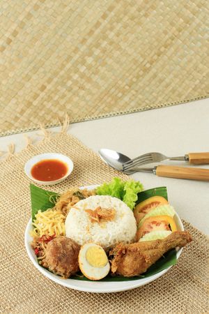 Plate of nasi uduk with rice and chicken