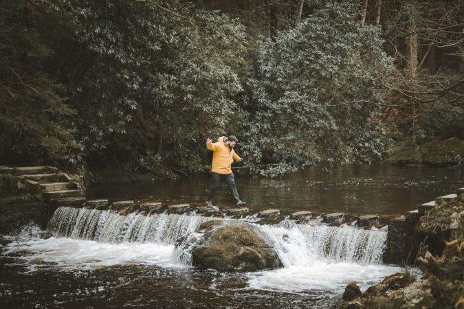 Man crossing river on stepping stones