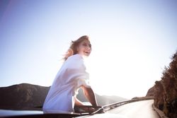Woman standing out through a vehicle’s sunroof