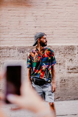 Faceless female taking photo of bearded man