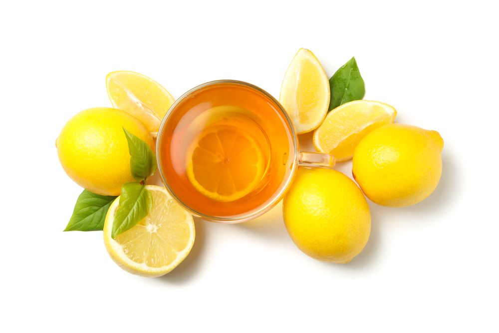 Tea and lemons isolated on bright background, top view