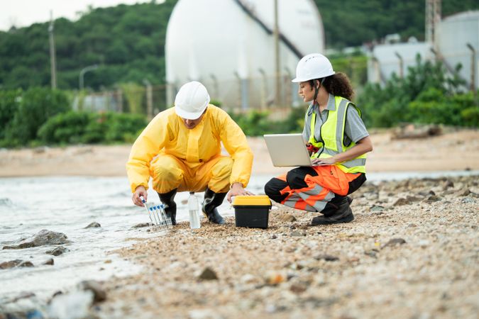 Environment scientist with team analysing waste water collecting sample for research