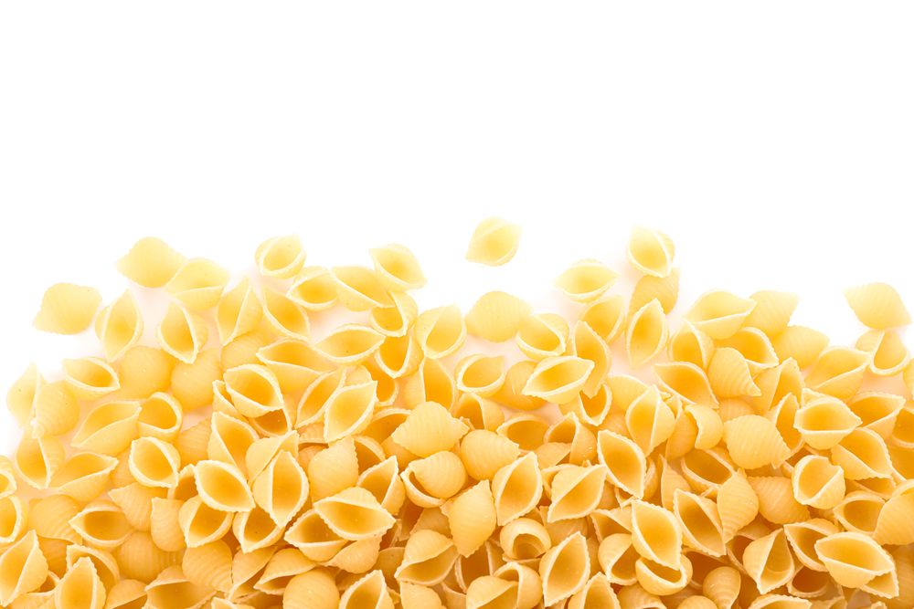 Pasta isolated on light background. Uncooked whole wheat pasta