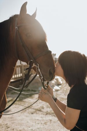 Woman kissing horse on ranch