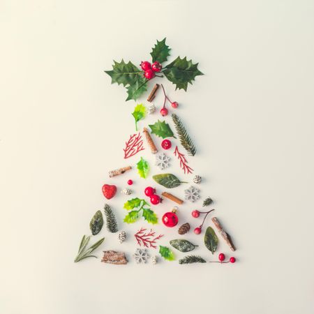 Christmas tree made of various winter and holiday objects on light paper